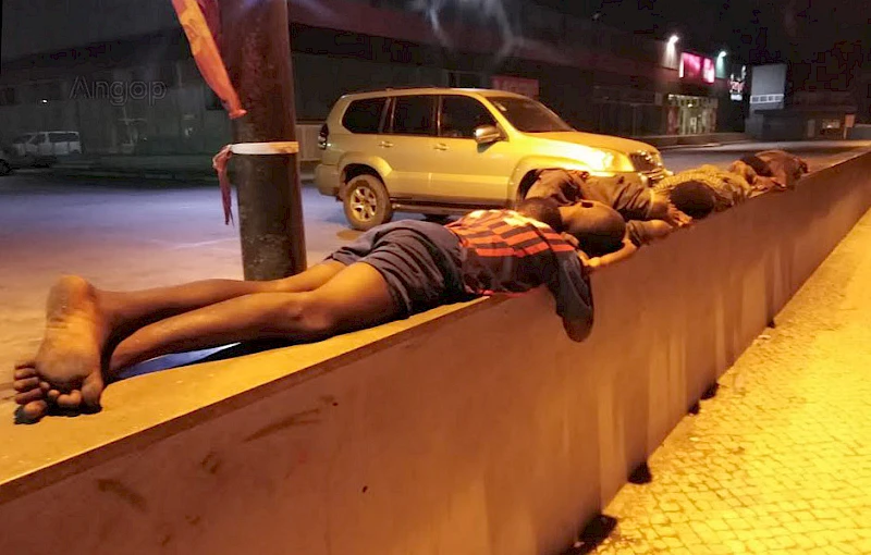 Crianças de rua dormem por cima de um muro